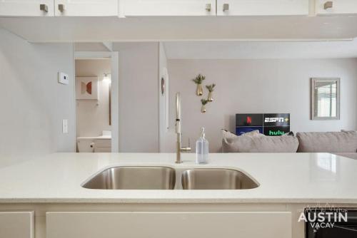 奥斯汀Cook and Gather Around in a Fully Equipped Apartment的厨房配有水槽和白色台面