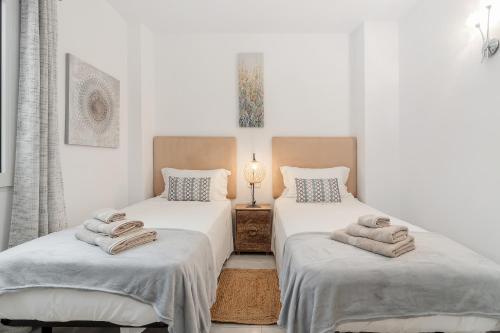莫莱拉Apartamento mediterráneo en el alma de Moraira的客房内的两张床和毛巾