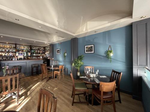 瑟索渡轮旅馆的一间拥有蓝色墙壁和桌子的餐厅和一间酒吧