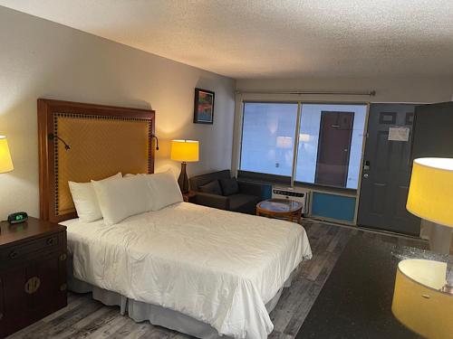 布兰森Branson Ozarks Inn的配有一张床和一把椅子的酒店客房