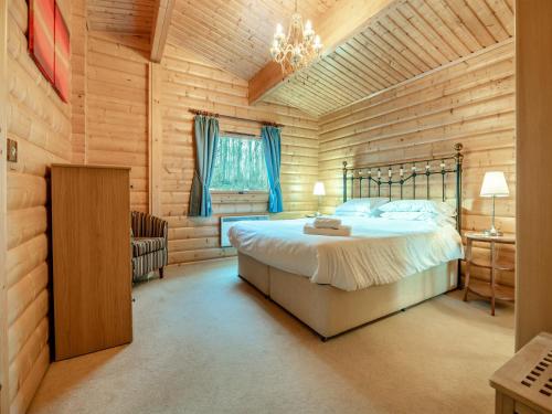 LegbourneForest Lodge的一间卧室设有一张床和木墙