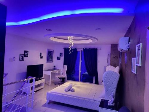 安吉利斯Kandi Tower 3, premium 1BR with 2CR & 2 balcony.的客厅配有床和蓝色的灯光
