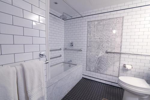 纽约The Frederick Hotel Tribeca的白色的浴室设有浴缸和卫生间。