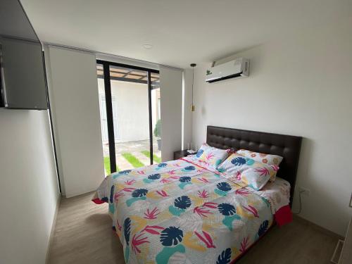 萨利纳斯Suite Nueva en Salinas - Chipipe, en conjunto privado的一间卧室配有一张带五颜六色棉被的床