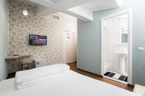 布加勒斯特拉吉尔酒店的卧室配有一张床,墙上配有电视。