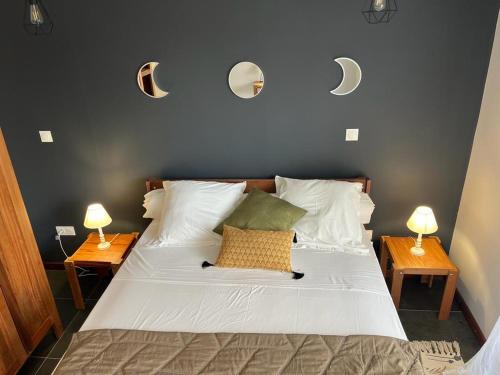 BourdaLA RESIDENCE DU ROCHER的卧室配有一张床,墙上挂着两盏灯