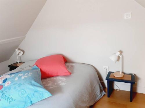 特鲁瓦LE STUPLEX的一张带两个枕头的床和一张带台灯的桌子