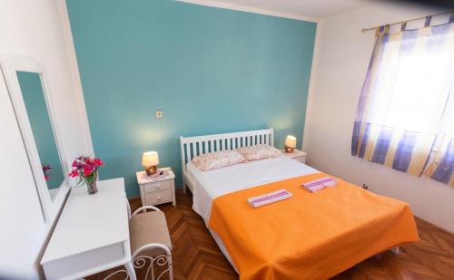 塞尔察Villa Adriana的小卧室配有带橙色毯子的床