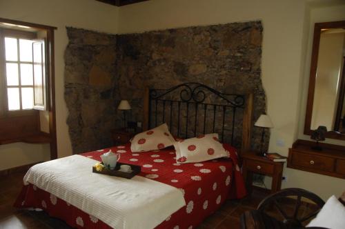 巴列埃尔莫索棕榈乡村民宿的一间卧室配有一张带红色和白色床单的大床