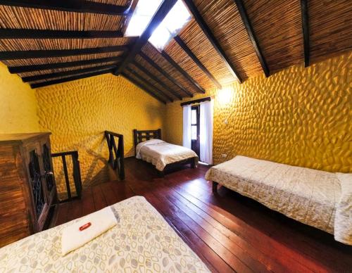 El CocuyHotel Museo la Posada del Molino的一间卧室,配有两张床