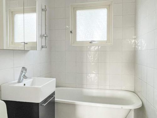 英斯约Holiday home YNGSJÖ III的白色的浴室设有水槽和浴缸。