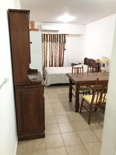 罗萨里奥Monoambiente - Barrio Martin的客房设有桌子、床和桌椅。