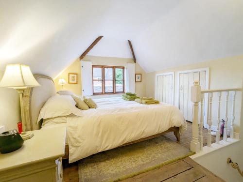 奇切斯特Truffle Cottage, Chichester的一间卧室设有一张大床和一个窗户。