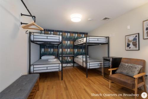 波士顿West Broadway Quarters by Thatch的客房设有三张双层床和一张桌子。