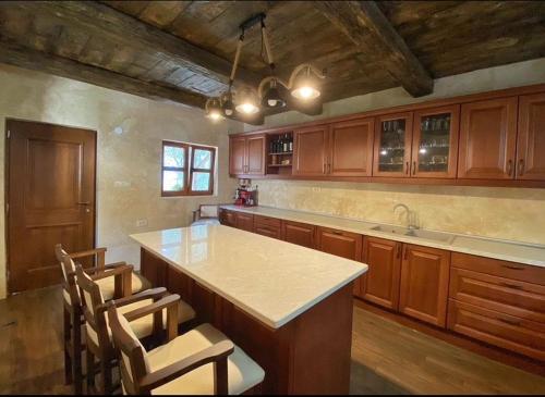 巴尔OLIVE QUEEN Rustic Villa的一个带木制橱柜的厨房和一个带椅子的岛屿