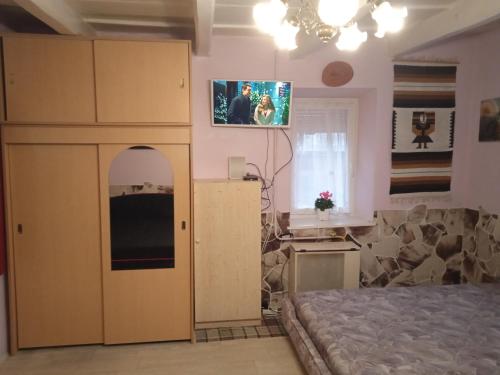 锡尔沃斯瓦里德Liána Vendégház的卧室配有一张床,墙上配有电视。