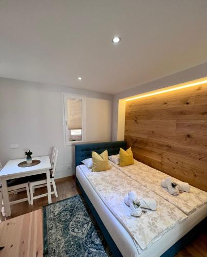 马拉加Apartamentos Prestige Málaga Suites的一间卧室配有一张带木制床头板和一张桌子的床。