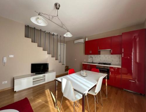 BovinoLa Dolce Vita的厨房配有红色橱柜和白色的桌椅