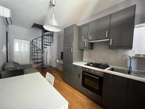 BovinoLa Dolce Vita的厨房配有黑色橱柜和白色台面