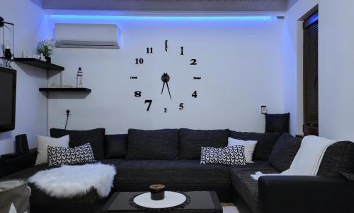 艾斯特根Palatinus Apartman Esztergom的客厅配有沙发和墙上的时钟