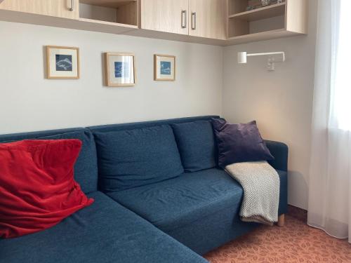 查普伊Villa Baltic Chałupy - Apartament nr 14A的客厅配有带两个枕头的蓝色沙发