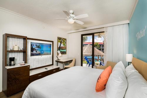 普拉亚弗拉明戈弗拉明戈海滩玛格丽塔维尔海滩度假村的一间卧室配有一张床和一台平面电视