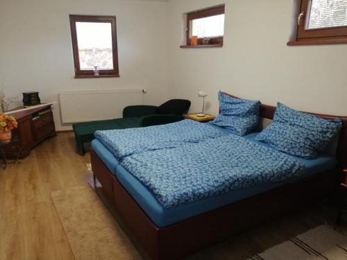 波普拉德Útulný Domček Privat Bedrich的一间卧室配有一张带蓝色棉被的床