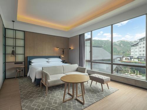 茂名茂名喜来登温泉度假酒店的酒店客房设有一张床和一个大窗户