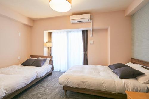 福冈LINK HOUSE HOTEL - スマート無人ステイ - Unmanned design hotel的一间卧室设有两张床和窗户。