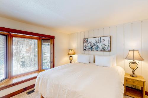 凯彻姆Ideal in Idaho的卧室配有白色的床和2扇窗户。
