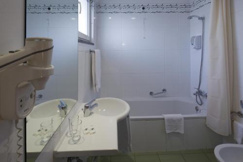 丰沙尔奥尔葵迪亚酒店的白色的浴室设有水槽和浴缸。