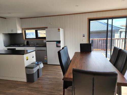 Mount RumneyMount Rumney Escapes - 3 Seaview Wombat House的厨房以及带桌椅的用餐室。