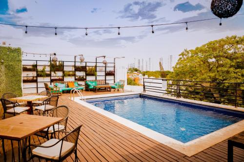 坎昆Nomads Hotel, Hostel & Rooftop Pool Cancun的一座建筑顶部的甲板上设有一个游泳池