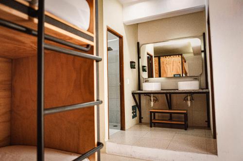 坎昆Nomads Hotel, Hostel & Rooftop Pool Cancun的客房设有双层床和镜子。