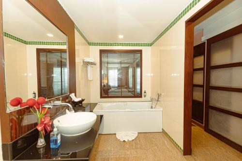 七岩广阔太平洋君主Spa度假酒店的浴室配有盥洗盆、浴缸和镜子
