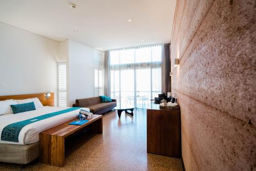 埃克斯茅斯曼塔雷宁格罗海滩度假酒店的一间卧室配有一张床和一个沙发