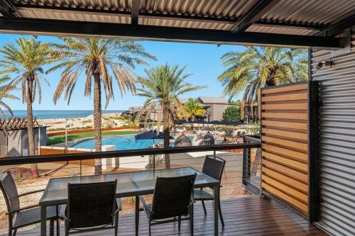埃克斯茅斯曼塔雷宁格罗海滩度假酒店的海滩景阳台配有桌椅