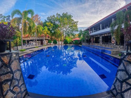 达瓦拉维桑陶里亚维尔德酒店的一座大型蓝色游泳池,位于大楼旁边