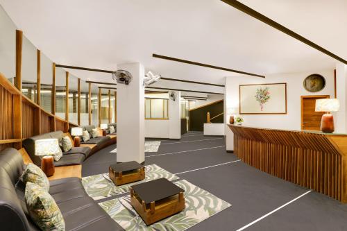 提喀迪Keys Prima By Lemon Tree Hotels, Thekkady的办公室大厅配有沙发和桌子,位于地板上