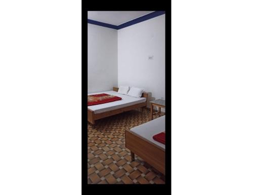 乌德尔格希Hotel Krish Motel and Restaurant, Uttarkashi的带两张床和镜子的客房