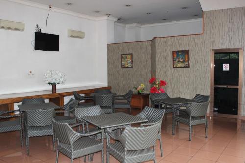 雅加达Hotel 678 Cawang powered by Cocotel的餐厅设有桌椅和平面电视。