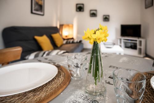 LombrayGite Pak'Home maison à la campagne 3 étoiles avec wifi的一张桌子,上面有黄色花瓶