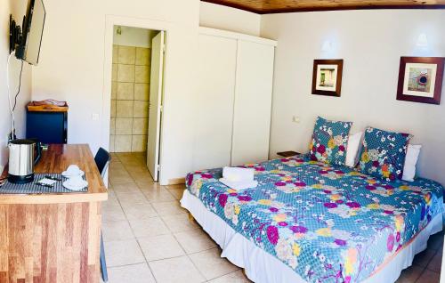 KumakLe Passiflore的一间卧室配有一张床和一张木桌