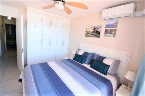 乌姆德洛蒂Cozumel 317的一间卧室配有一张带蓝色和白色枕头的床