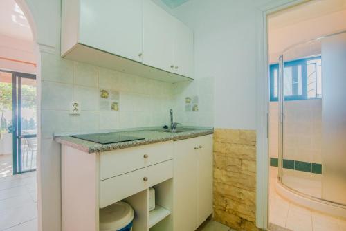 AchílleionFamily apartment 2的白色的厨房设有水槽和淋浴