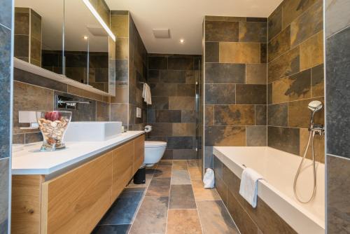 萨斯格伦德Montela Hotel & Resort - Suiten的带浴缸、卫生间和盥洗盆的浴室