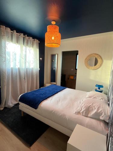 圣梅卢瓦代翁德La Belle Mélorienne的一间卧室配有一张带蓝色毯子的大床