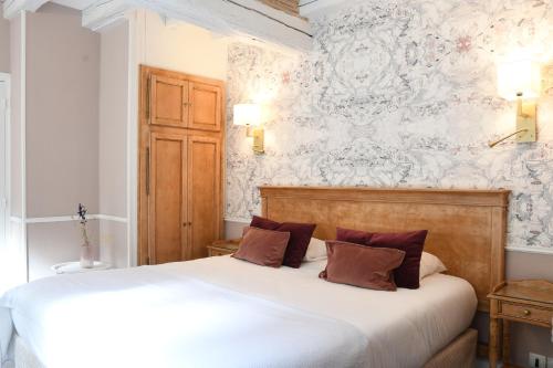 阿瓦隆Le Moulin Des Ruats的卧室配有白色的床和白色的墙壁