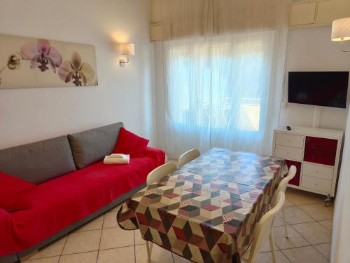 蒂勒尼亚Residence Hotel Vittoria的客厅配有红色的沙发和桌子