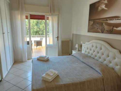蒂勒尼亚Residence Hotel Vittoria的一间卧室配有一张大床和两条毛巾